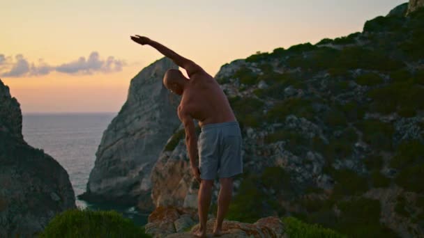 Pasujący Mężczyzna Ćwiczący Jogę Krawędzi Oceanu Sportowy Jogin Treningowy Sunset — Wideo stockowe
