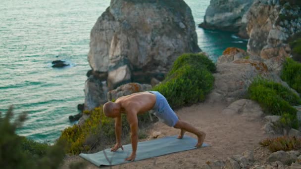 Muscular Cara Treinamento Ioga Asana Alongando Borda Penhasco Oceano Bonito — Vídeo de Stock