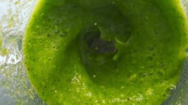 Yeşil, lezzetli sebze karışımı elektrikli mikserle karıştırılmış. Üst manzarayı kapatın. Doğal organik smoothie 'yi çiğ taze sebze bitkilerinden süper yavaş çekimde hazırlıyorum. Tabakta dönen diyet kokteyli.