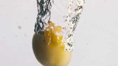 Yakın plan patatesler arka planda suya düşüyorlar. Soyulmuş sebzeler, şeffaf sıvının içinde kıvrılırlar. Güzel doğal vejetaryen yemek reklamı. Sağlıklı organik gıda konsepti pişirmek