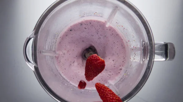 加入五彩缤纷的成熟浆果 混合粉红的冰沙在超级慢镜头 美味的草莓蓝莓石榴落在水果味饮料的顶部 在搅拌机中配制天然奶昔 — 图库照片