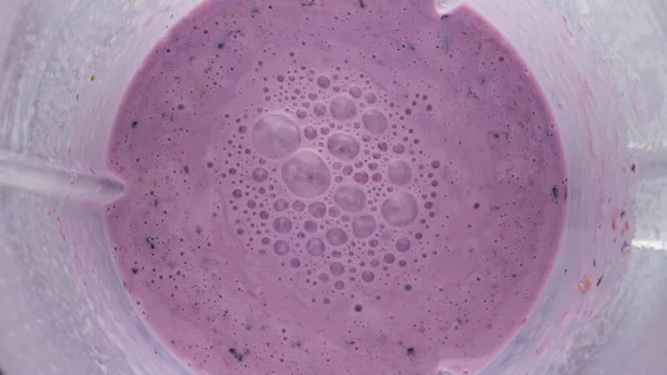 在搅拌机碗中混合新鲜的浆果 闭合上视图 旋转的表面维生素和气泡混合 紫色有机奶昔准备在电动搅拌机超慢动作 健康营养 — 图库照片