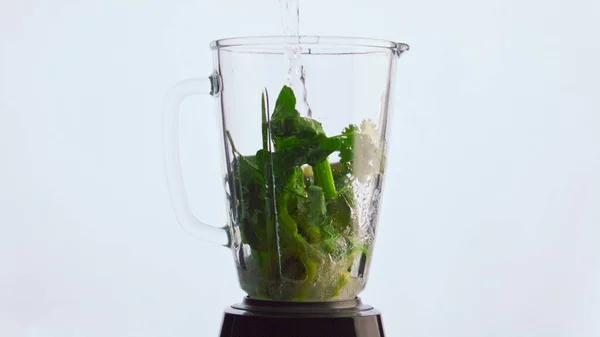 믹서에 생야채를 흐르는 동작을 시킵니다 배경에 액체로 채워진 야채와 허브가 — 스톡 사진