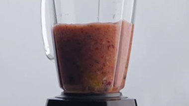 Doğal meyve kokteyli cam elektrikli mikserle karıştırılıyor. Yakın çekim. Karıştırıcının içinde süper yavaş çekimde dönen lezzetli organik karışım. Beyaz arka planda antioksidan vejetaryen tatlısını hazırlıyorum..