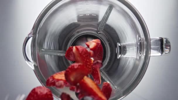 多汁美味的草莓蓝莓石榴滚落在搅拌机碗中 动作非常缓慢 电动搅拌机混合新鲜的有机浆果顶部视图 制备维生素健康甜果冻 — 图库视频影像