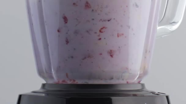 在玻璃搅拌机碗中加入新鲜牛奶 慢速搅拌 切碎美味的水果 在电动搅拌机中 用草莓蓝莓片封闭旋转的乳液 烹调维生素鸡尾酒 — 图库视频影像