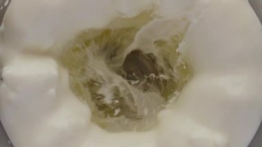 Blender kasesinin içine taze beyaz süt sıçrıyor. Organik süt ürünleri karışımı. Elektrikli mikserde çok yavaş karıştırılıyor. Smoothie kokteyli için en iyi protein içeriği