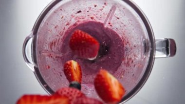 Lezzetli böğürtlenler süper yavaş çekimde kırmızı lezzetli smoothie 'ye ekleniyor. Çilekli, böğürtlenli, nar aromalı, kıvrımlı. Ev yapımı organik yoğurt pişirmek..