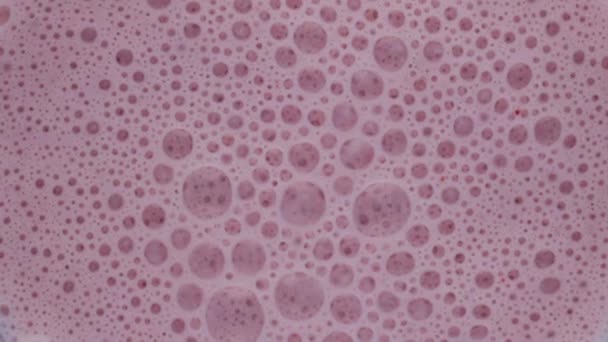 ブレンダーボウル内の飲料表面に泡が付いているピンクベリースムージーを閉じます トップビューおいしいフルーツカクテルミキサー超スローモーションで渦巻く 健康的なライフスタイルのためのおいしい自然飲料 — ストック動画