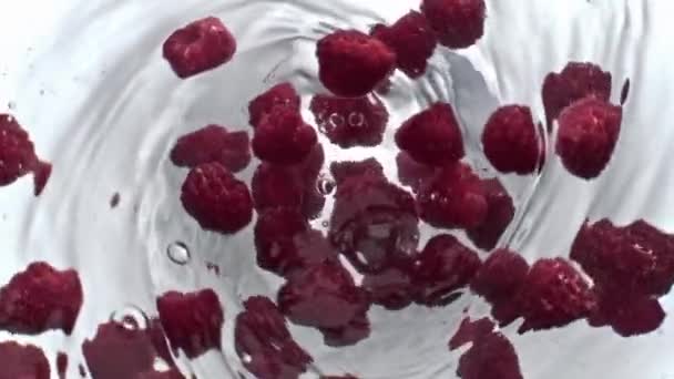 ジューシーなラズベリードリンクがトップビューを回転 透明なフルーツカクテル漏斗をガラス製品の中に閉じます 容器の遅い動きにピンクの果実渦と新鮮な冷たい水を飲む デトックスアクアコンセプト — ストック動画