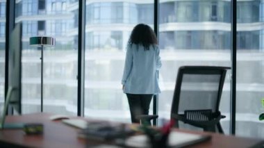 Milenyum direktörü çözümü modern ofis görüşünde düşünür. Panorama pencerelerini izleyen stresli iş kadını. CEO 'nun iflasla ilgili endişeleri var. Sinirli işçi tek başına karar veriyor. 