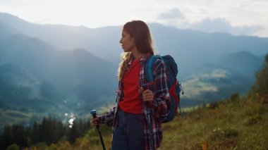 Thoughtful woman explore picturesque nature. Carefree hiking girl walk travel mountain landscape at sunrise close up. Tired traveler going trekking on summer holiday activity. Wanderlust relax concept