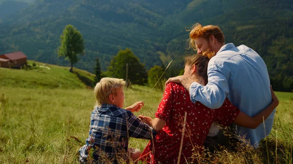 Loving Parents Hugging Sitting Son Mountain Slope Sunny Day Relaxed — Stockfoto