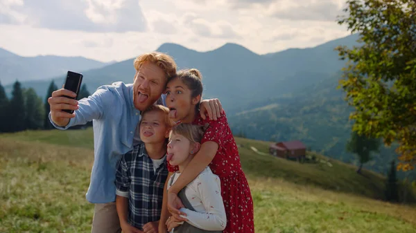 Joyful Family Taking Selfie Sticking Tongues Using Cellphone Green Hill — Fotografia de Stock