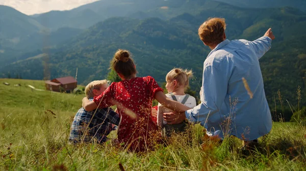 Счастливые Родители Сидят Зеленый Травяной Холм Беззаботными Детьми Солнечный День — стоковое фото