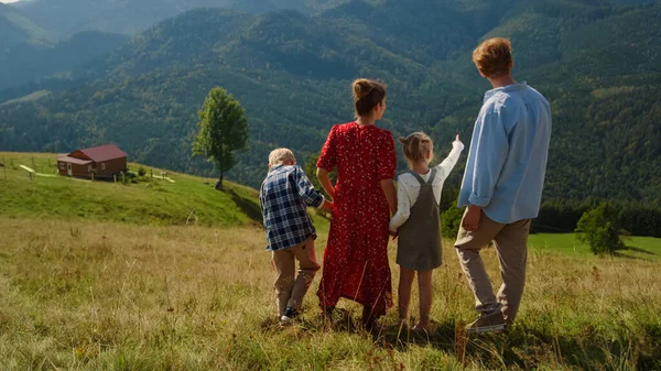 Вид Сзади Расслабленной Семьи Спускающейся Зеленого Холма Наслаждающейся Летним Отпуском — стоковое фото