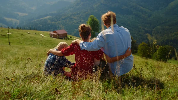 Unrecognizable Family Hugging Sitting Green Grass Hill Unknown Parents Spending — Foto de Stock