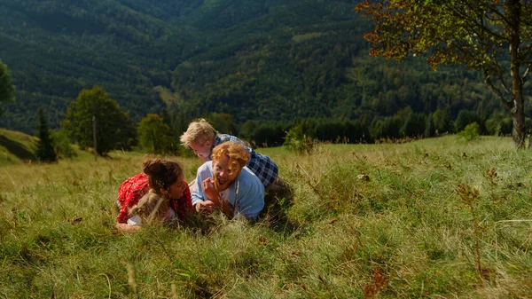 Happy Family Relaxing Grass Mountain Slope Together Smiling Parents Lying — kuvapankkivalokuva