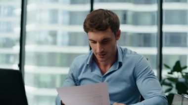 Memnun mali raporları okuyan heyecanlı genç adam ofis masasını kapatıyor. Mutlu profesyonel yönetici şirket çalışmalarına seviniyor. Başarılı işçi iş başarısını kutlarken gülümsüyor.