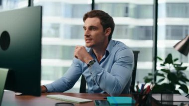 Mutlu yönetici, bilgisayar ekranında modern ofis kapanışında kurumsal çalışmaların sonuçlarını tatmin etti. Genç işadamı, iş verilerini analiz ederek kâr artışına seviniyor. Girişimci başarılı hissediyor