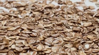 Çiğ yulaf ezmesi, sağlıklı kahvaltı hazırlamak için doğal yoğurdun içine düşer. Süt sıvısının üzerinde yatan taze mısır gevreği süper yavaş çekimde dönüyor. Sağlıklı yaşam için lezzetli organik besin.