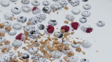 Çok yavaş çekimde gevrek granola meyveli yoğurtla sağlıklı kahvaltı hazırlıyorum. Lezzetli gevrekler sulu ahududu böğürtlenli sütlü tatlıya düşüyor. Doğal malzemeler..