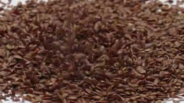 Süt ürünleri üzerine dökülen kahverengi keten tohumları yakın plan. Doğal antioksidan keten tohumları çok yavaş çekimde lezzetli yoğurda ekleniyor. Sağlıklı ev yapımı organik kahvaltı hazırlıyorum..