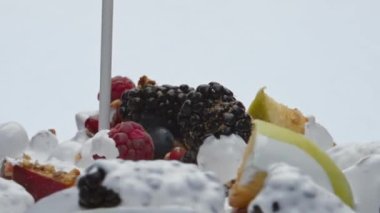 Taze yoğurt gevrek müsli ile böğürtlenleri karıştırıyor. Hem de çok yavaş çekimde. Böğürtlenli ahududu elma şeftalisi ve tatlı granola üzerine akan doğal süt kremi. Besleyici sağlıklı yiyecekler..