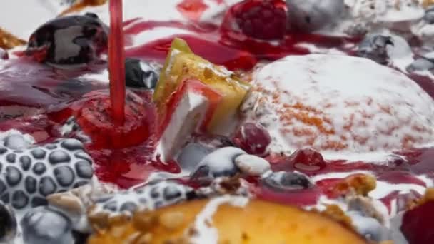 赤い甘いジャム果物に注ぐMuesli新鮮なギリシャヨーグルトのクローズアップに浸した ラズベリーブラックベリーのピーチ超スローモーションでオートミールに滴下おいしいマーマレード 栄養価の高い粥 — ストック動画