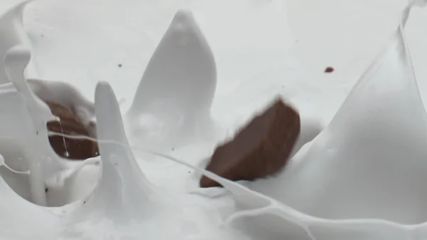 Pedaços Chocolate Doce Caindo Leite Orgânico Fresco Fazendo Salpicos Movimento — Fotografia de Stock