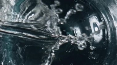 Filtrelenmiş sıvı dolgu kabını kapat. Bardaktan doldurulmuş taze içecek. Cam yüzeyden aşağı maden suyu akıyor. Temiz kadehin içinde şeffaf bir içecek var. Soğuk kokteyl konsepti