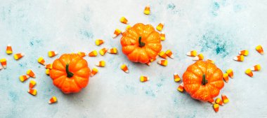 Cadılar Bayramı balkabağı ve mısır şekeri afişi mavi arka planda. Kopyalama alanı olan üst görünüm