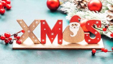Kırmızı Noel topları, böğürtlenler, köknar dalları, çam kozalakları ve Xmas yazısıyla mavi ya da yeni yıl arkaplanı
