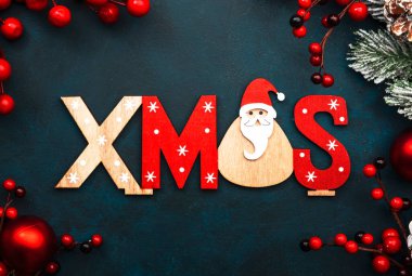 Kırmızı Noel topları, böğürtlenler, köknar dalları, çam kozalakları ve Xmas yazısıyla mavi ya da yeni yıl arkaplanı