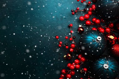 Mavi Noel ya da yeni yıl arkaplanı, mavi Noel topları, kırmızı böğürtlen ve yıldızlar ve kar taneleri, üst manzara, metin için yer