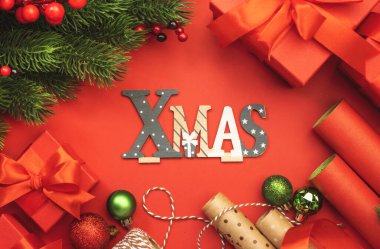 Kutular, kurdeleler, fiyonklar, ambalaj kağıtları, ladin dalları ve bayram dekorlarıyla mutlu noeller. Hediye paketi, tatil hazırlığı. Üst görünüm