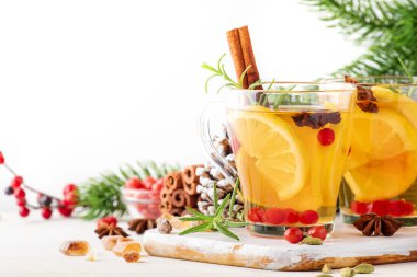 Noel veya Yeni Yıl sofrasında limonlu, kızılcıklı, yabanmersinli ve baharatlı kış çayı, beyaz arkaplan, kopyalama alanı