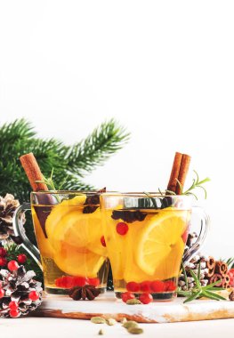Noel veya Yeni Yıl sofrasında limonlu, kızılcıklı, yabanmersinli ve baharatlı kış çayı, beyaz arkaplan, kopyalama alanı