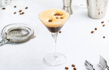 Espresso martini, votka, kahve likörü, şurup ve buz, siyah arka plan, bar aletleri ile son moda alkollü kokteyl.