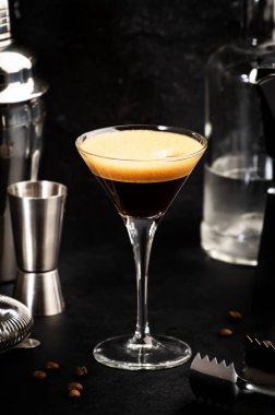 Votka, kahve likörü, şurup ve buz, siyah arka plan, bar aletleriyle espresso martini kokteyli.