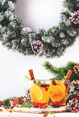 Noel veya Yeni Yıl sofrasında limonlu, kızılcıklı, yabanmersinli ve baharatlı kış çayı, beyaz arkaplan, kopyalama alanı