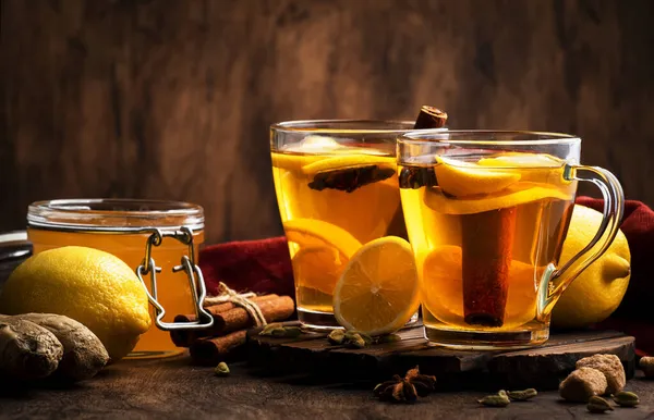 生姜と熱い黒冬のお茶 レモンとスパイス 素朴な木製のテーブルの背景にガラスカップで免疫ブースタードリンク コピースペース — ストック写真