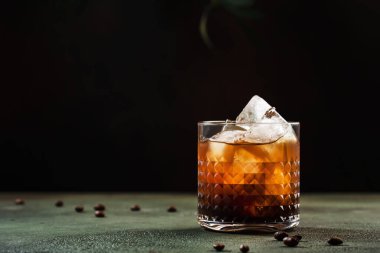 Siyah Rus kokteyli, son moda alkollü votka, kahve likörü ve buz, paslı yeşil arka plan