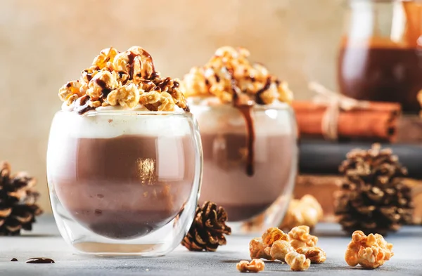 ホイップクリームと冷たい冬のチョコレートデザート ベージュの背景にガラスのポップコーンとキャラメルトッピング テキストのための場所 — ストック写真