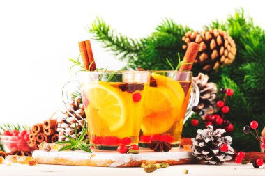 Noel veya Yeni Yıl sofrasında limonlu, kızılcıklı, yabanmersinli ve baharatlı kış çayı, beyaz arkaplan, kopyalama alanı