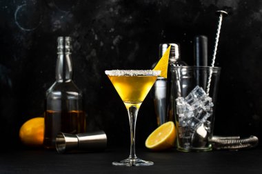 Konyak, likör, limon suyu ve buzlu kokteyl. Siyah arkaplan, bar araçları, gece atmosferi