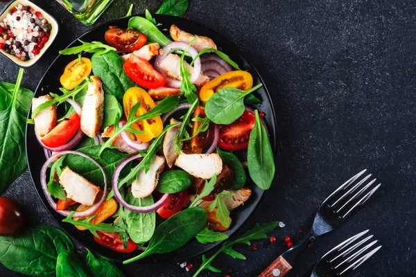ほうれん草と健康的なサラダ グリルチキン トマト アルグラと赤玉ねぎ 黒いテーブル コピースペース — ストック写真