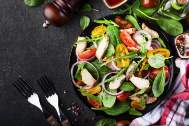 Ispanaklı sağlıklı salata, ızgara tavuk, domates, roka ve kırmızı soğan. Siyah tablo, boşluğu kopyala