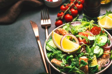 Tavuk, domates, roka, soğan, avokado, susam tohumu ve limon yağı soslu taze salata. Sağlıklı yiyecekler. Üst Manzara. Kahverengi masa