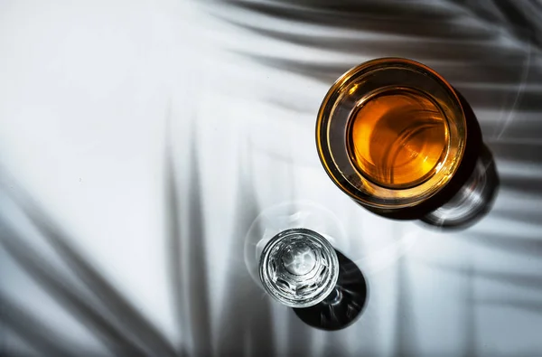 ガラスの強い飲み物 コニャックとウォッカ 強い光と厳しい影を持つ白い背景 — ストック写真